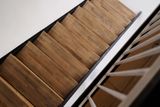 Holztreppe mit Holzstufen und weißem Geländer, von oben gesehen